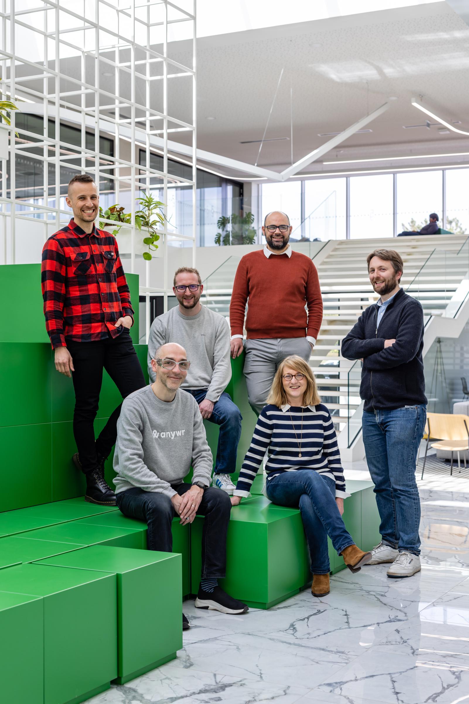 Responsable souriante en veste, debout devant un utilitaire aux couleurs de l’entreprise